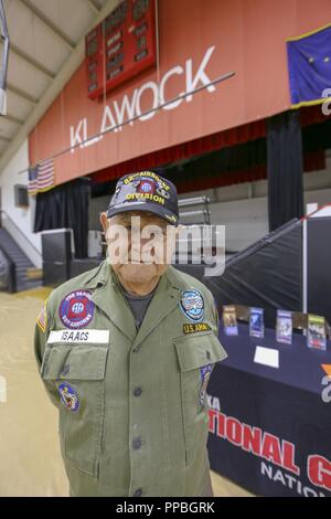 Veteran und Klawock elder Aaron Isaacs steht stolz vor dem AKARNG recruiting Anzeige Tabelle während ein veteran Totem Pole heben Feier an der Schule Gymnasium in der Stadt Klawock auf Prince of Wales Island, Nov. 17, 2018. Isaacs, einem ehemaligen Alaska Armee Scots Guards und U.S. Army 82nd Airborne Fallschirmjäger und aktuellen Mitglied der Alaska State Defense Force, kam mit der Idee der Schaffung eines Totempfahls Veteranen zu ehren. Isaacs, einem ehemaligen Alaska Armee Scots Guards und U.S. Army 82nd Airborne Fallschirmjäger und aktuellen Mitglied der Alaska State Defense Force, kam mit der Idee der Crea Stockfoto