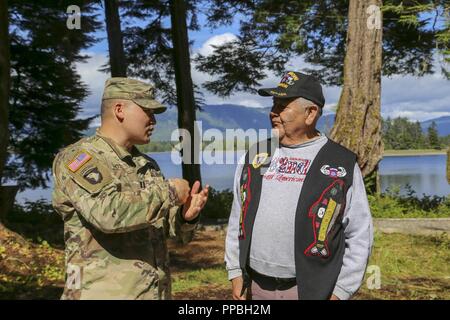 Alaska Army Guard Kapitän Walter Hotch-Hill, 1st Battalion, 297Th Infantry Regiment, spricht mit Klawock elder Aaron Isaacs, einem ehemaligen Alaska Armee Scots Guards und U.S. Army 82nd Airborne Fallschirmjäger und aktuellen Mitglied der Alaska State Defense Force, wie er auf die Idee, den Totem Pole, die allen Veteranen nach Abschluss der Veteranen Totem Pole Anhebung Zeremonie in der Stadt Klawock auf Prince of Wales Island, Nov. 18, 2018 Ehre kam. Mitglieder der Alaska Air und Army National Guard und Alaska State Defense Force nahmen an einer dreitägigen Feier zu Ehren Alaska Tierarzt Stockfoto