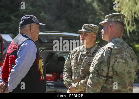 Alaska Army Guard Command Sgt. Maj. James Nyquist, rechts, und Kapitän Walter Hotch-Hill, sowohl mit 1St Battalion, 297Th Infantry Regiment, sprechen mit Klawock elder Aaron Isaacs, einem ehemaligen Alaska Armee Scots Guards und U.S. Army 82nd Airborne Fallschirmjäger und aktuellen Mitglied der Alaska State Defense Force, wie er auf die Idee, den Totem Pole, die allen Veteranen nach Abschluss der Veteranen Totem Pole Anhebung Zeremonie in der Stadt Klawock auf Prince of Wales Island, Nov. 18, 2018 Ehre kam. Mitglieder der Alaska Air und Army National Guard und Alaska State Defense Force particip Stockfoto