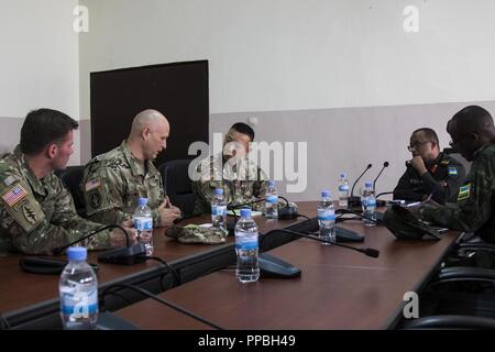 Us-Armee Oberst Doug Phillips, Mitte, team Offizier, 28 Combat Support Hospital, Schriftsatz Brig. Gen. Lapthe Flora, stellvertretender kommandierender General der US-Armee Afrika, während MEDRETE 18-5 an der militärischen Krankenhaus Ruanda, Kigali, Ruanda, Aug 20., 2018. MEDRETE 18-5 ist die erste gemeinsame Anstrengungen für eine medizinische Bereitschaft Übung zwischen der Ruandischen Regierung und der US-Armee Afrika. Die Übung ist Teil einer Reihe von medizinischen Readiness Training, dass die US-Armee Afrika geplant ist innerhalb der verschiedenen Länder in Afrika zu erleichtern, und dient als eine Chance für die Partnerschaft Militärs Stockfoto