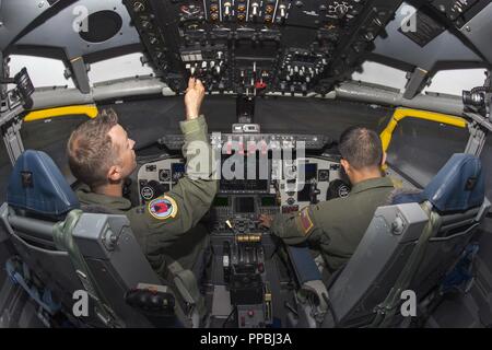 Us-Luftwaffe Kapitän Josh Welch, Links, und 2 Lt Kent Melendez, rechts, beide Piloten auf den 50 Luftbetankung Geschwader zugewiesen, Pre-flight Verfahren in der KC-135 Flight Simulator bei MacDill Air Force Base, Fla, Aug 17, 2018 durchführen. Piloten führen Sie mehrere Simulatorflüge jedes Jahr die Prüfung ihrer Kenntnisse der Flugzeuge und ihrer Fähigkeit, ein breites Spektrum von Notfallszenarien zu behandeln. Stockfoto