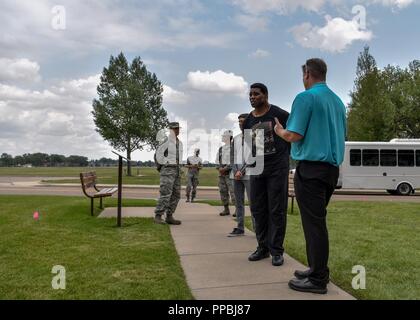 Herschel Walker, 1982 Heisman Trophy Winner, hört zu, Glenn Robertson, 90 Raketen Flügel Tour Guide, während einer Tour von ZB. Warren Air Force Base, Wyo. August 14, 2018. Während der Tour, Walker gelernt über die reiche Geschichte der ZB. Warren AFB. Stockfoto