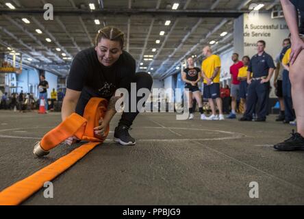 Atlantik. (Aug. 27, 2018) Aviation Machinist Mate Airman Wendy PenaCervantes, von Las Vegas, Brötchen, ein firehose bei der Schadensbegrenzung Olympics im Hangar Bucht von dem Flugzeugträger USS George H.W. Bush (CVN 77). Das Schiff ist im Gange, die Durchführung von routinemäßigen Übungen Träger bereit zu halten. Stockfoto