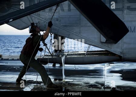 Lance Cpl. Wyatt McDonald, ein flightline Mechaniker mit Marine Medium Tiltrotor Squadron 262 (verstärkt), sichert die Rotorblätter eines CH-53E Super Stallion Hubschrauber auf dem Flugdeck der Amphibisches Schiff USS Wasp (LL 1), vor der Küste von Okinawa, Japan, August 25, 2018. McDonald, ein Eingeborener von Bakersfield, Kalifornien, graduiert von Centennial High School im Frühjahr 2016, bevor er in der Marine Corps im November 2016. VMM-262 (Rein) ist die Aviation Combat Element für die 31 Marine Expeditionary Unit. Marinesoldaten und Matrosen mit der 31 MEU, bestehend aus einem Befehl Element, ein Stockfoto