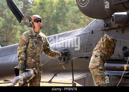 Der Soldat mit der 6. Staffel, 17 Cavalry Regiment, 4 Combat Aviation Brigade, 4 Infanterie Division bereitet eine AH-64 Apache Kampfhubschrauber der Vorwärts Rüstung und Tanken auf Kraftstoff während in der Sabre Vortex Training übung in Grafenwöhr, Deutschland, 29. August 2018 teilnehmen. Die Übung ist Teil des Engagements 4 CAB zu Atlantic lösen, Ausbildung neben europäischen Verbündeten weiterhin Frieden und Stabilität in der Region zu gewährleisten. Stockfoto