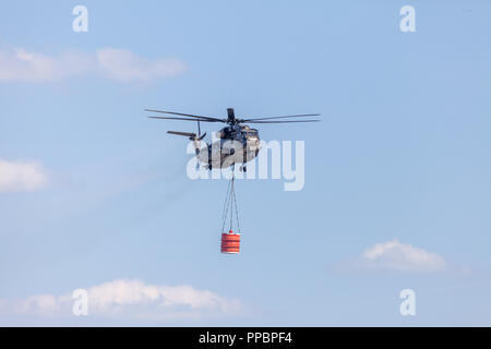 BERLIN/Deutschland - VOM 28. JUNI 2018: Sikorsky S-65, Transporthubschrauber CH-53 der Bundeswehr fliegt mit einem Wassertank in Berlin, Deutschland. Stockfoto