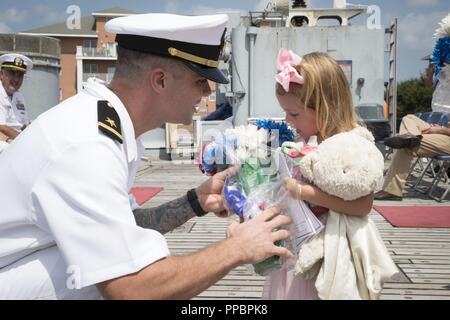 NORFOLK, Virginia (Aug. 31, 2018), der Stern Ryan Kuhn, von Snow Hill, Maryland, zu USS Gerald R. Ford's (CVN 78) Reaktor Abteilung zugewiesen, gibt Blumen an seine Tochter während seiner Inbetriebnahme Zeremonie an Bord des Schlachtschiffes USS Wisconsin (BB 64). Kuhn beauftragte als ensign nach 15 Jahren Dienst als nukleare Elektriker mate. Stockfoto