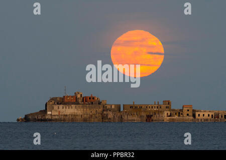 Dorchester, Dorset, Großbritannien. 24. September 2018. UK Wetter. Die Harvest Moon erhebt sich hinter dem historischen des 19. Jahrhunderts Portland Wellenbrecher Fort auf der äußeren Mole Portland Harbour in Dorset. Der jetzt aufgegebenen fort Auch bekannt als Karierten Fort wurde zwischen 1868 und 1878 erbaut und steht unter Denkmalschutz. Foto: Graham Jagd-/Alamy leben Nachrichten Stockfoto