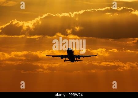 Luton Airport, London, Großbritannien. 24. Sep 2018. UK Wetter: die Silhouette eines Airbus A320 Flugzeuge, die bei Sonnenuntergang Quelle: Nick Whittle/Alamy leben Nachrichten Stockfoto