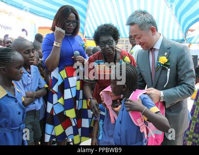 Windhoek. 24 Sep, 2018. Der chinesische Botschafter in Namibia Zhang Yiming (R) hilft ein Mädchen auf einen Beutel in Windhoek, Namibia auf Sept. 24, 2018. Eine chinesische Nächstenliebe hat 60.000 Säcke mit Schulmaterial, um von den namibischen Ministerium für Unterricht, Kunst und Kultur gespendet. Die Spende, die von der Beijing - gegründete chinesische Grundlage für die Bekämpfung der Armut (CFPA), wurde durch eine Initiative der Panda Pack Projekt, die bereits über 5 Millionen Schüler in China profitiert genannt. Credit: Wu Changwei/Xinhua/Alamy leben Nachrichten Stockfoto