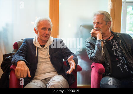 München, Bayern. 04 Sep, 2018. Klaus Eberhartinger (L-R), Sänger der Ersten Allgemeinen Verunsicherung (SAV) und Thomas Spitzer, Gitarrist und Texter der SAV, sitzen auf einem Bürgersteig in einem Interview mit dpa. Die SAB endet nach mehr als 40 Jahren und im Gegensatz zu seiner humorvollen Ruf, Blätter mit ein sehr politisches Album. Credit: Lino Mirgeler/dpa/Alamy leben Nachrichten Stockfoto