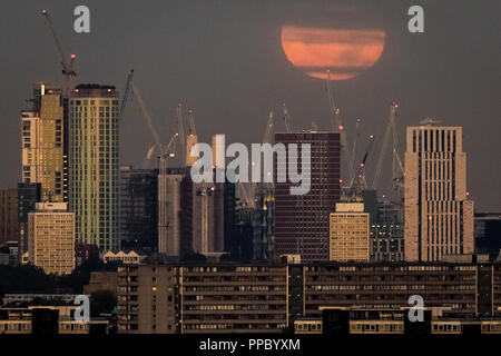 London, Großbritannien. 25. September, 2018. Harvest Moon sets, die am frühen Morgen über die Stadt. Credit: Guy Corbishley/Alamy leben Nachrichten Stockfoto