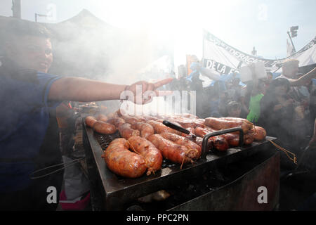 Buenos Aires, Argentinien. 24 Sep, 2018. Eine Wurst Verkäufer macht den Sieg Zeichen, Symbol des linken politischen Bewegungen in Argentinien, in einem Protest gegen die Sparpolitik der konservativen Regierung. Der argentinischen Föderation der Gewerkschaften hat für einen nationalen Streik über Wirtschaftspolitik Präsident Macri. Der Protest richtet sich gegen die Sparpolitik, die die Regierung sich verpflichtet hat, den Internationalen Währungsfonds (IWF) geleitet. Credit: Claudio Santisteban/dpa/Alamy leben Nachrichten Stockfoto