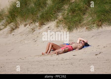 Sturz, East Sussex, UK. 19 Sep, 2018. UK Wetter: schönen sonnigen Tag am Strand von Camber Sands mit Menschen genießen die heißen sonnigen, herbstlichen Wetter. Heiß genug heute für dieses Paar ein Sonnenbad zu tun. © Paul Lawrenson 2018, Foto: Paul Lawrenson/Alamy leben Nachrichten Stockfoto