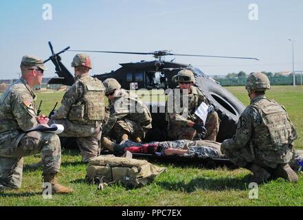 U.S. Army Staff Sgt. Jordan Dorn (links), der Medic platoon Sergeant für den Hauptsitz und die Konzernzentrale, 2nd Battalion 5th Cavalry Regiment, 1st Armored Brigade Combat Team, 1.Kavallerie Division wertet der US-Armee SPC. Brandon Espindola ein combat Medic, HHC, 2-5 Cav, 1 ABCT, 1 CD Mihail Kogalniceanu Airbase in Rumänien, 20. August 2018 zugewiesen. Soldaten durchgeführt Tabelle VIII Medic Skills Validierung, eine jährliche Schulung für Soldaten ihre militärische Spezialität berufliche Qualifizierung als combat Medic zu halten. Stockfoto