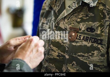 Brig. Gen. Robert G. Novotny, 57 Wing Commander, Stifte des Präsidenten hundert Medaille auf Staff Sgt. Andrew Wilson, 757Th Aircraft Maintenance Squadron Strike Aircraft Maintenance Unit F-15E Strike Eagle Fighter jet Mannschaft Leiter, an der Nellis Air Force Base in Nevada, 15 August, 2018. Es gibt nur vier andere Flieger auf aktiven - Aufgabe, dass die Registerkarte tragen. Stockfoto