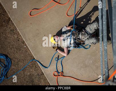 Flieger 1. Klasse Dimitri Repeshcuk, 9. Operation Support Squadron Radar, Flugplatz und Wetter Lehrling, senkt sich auf den Boden nach erfolgreichem Abschluss einen Turm klettern an der Beale Air Force Base, Kalifornien, Aug 16., 2018. Der kletterkurs umfasst den Unterricht, praktische Ausbildung und eine abschließende Prüfung Kompetenz in der Fähigkeit und Sicherheit zu demonstrieren. Stockfoto