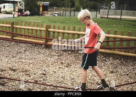Blonde Junge spielt auf einem Spiel Park Stockfoto