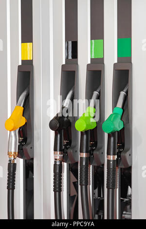 Farbe-kodierte Treibstoffdüsen an Tankstelle Stockfoto