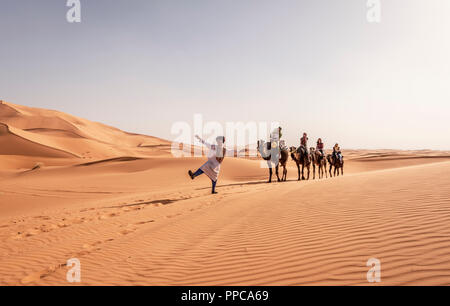 Touristen mit Beduinen Führer, Wohnwagen mit zwei Dromedar (Camelus dromedarius), Sanddünen in der Wüste Erg Chebbi, Merzouga Stockfoto