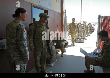 Spc. Kristine Kennedy (links), SPC. Hannah Beck (Mitte rechts) und Pvt. Juan Pastrana (rechts), alle Mitglieder der 213 Mitarbeiter Unternehmen, 213 Region Support Group, Pennsylvania Army National Guard, wiegen Staff Sgt. Jeremy Churchill (Mitte links), ein Alpha Company, 1st Battalion, 110Th Infantry Regiment, 56th Stryker Brigade Combat Team, 28 Infanterie Division Infanterist, und sein Gepäck während heraus - Verarbeitung an der National Training Center, Fort Irwin, Kalifornien 12.08.23. Stockfoto