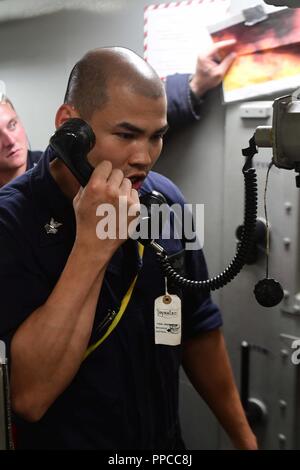 Ozean (Aug. 16, 2018) - Der Maschinist Mate 1. Klasse Thuc Pham meldet einen simulierten Brand während technische Universal-bohrer an Bord der Arleigh Burke Klasse geführte Anti-raketen-Zerstörer USS Ross (DDG71) im Atlantischen Ozean, Nov. 16, 2018. Ross, Vorwärts - Rota, Spanien bereitgestellt werden, wird auf der siebten Patrouille in den USA 6 Flotte Bereich der Maßnahmen zur Unterstützung der US-amerikanischen nationalen Sicherheitsinteressen in Europa und in Afrika. Stockfoto