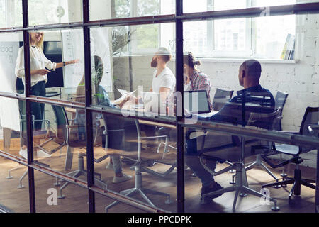 Arbeiten hart, um zu gewinnen. Geschäftsfrau, die Durchführung einer Präsentation mit Flipchart, während in der kreativen Arbeiten im Büro. Stockfoto