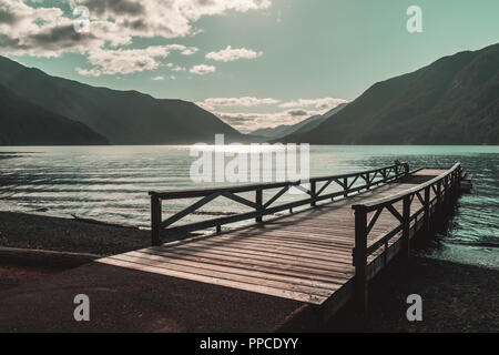 Holzsteg am Lake Crescent an einem schönen, sonnigen Nachmittag mit Bergen in der Ferne, Olympic National Park, Washington State, USA. Stockfoto