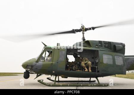 Mitglieder des 5 Sicherheitskräfte Squadron militärischen Gebrauchshund Abschnitt Vorbereiten mit der 54 Hubschrauber Geschwader zu nehmen während des Fluges Einarbeitung Training in Minot Air Force Base, Texas, 23.08.2018. Dies war das erste Mal das K-9 Einheit mit der 54 Hubschrauber Geschwader geflogen ist. Stockfoto