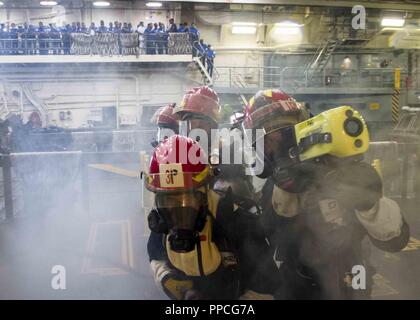 TRINCOMALEE, SRI LANKA (26. August 2018) Matrosen an Bord der San Antonio-Klasse amphibious Transport dock USS Anchorage LPD (23) Brandbekämpfung Techniken in der gut Deck demonstrieren, Sri Lanka navy Segler während einer planmäßigen Einsatz der Essex Amphibious Ready Group (ARG) und dem 13 Marine Expeditionary Unit (MEU). Anchorage und die eingeschifften Marineinfanteristen des 13. MEU führen ein Theater Sicherheit Zusammenarbeit Übung mit der Sri Lankan Navy und Marine. Teil einer wachsenden US-Sri Lanka naval Partnerschaft, die Übung ist auch eine Gelegenheit für die USA Siebente Flotte zu erkunden Stockfoto