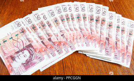 Geld auf den Tisch. Ein Fan von £ 1000 in der Bank von England 50 £ Sterling Banknoten. (Die Oberste ist fast verdeckt) Stockfoto