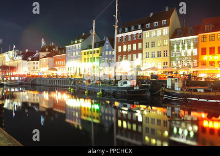 Hafen Nyhavn in Kopenhagen, Dänemark, durch Nacht mit Wasser Reflexionen