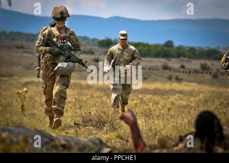 Us-Armee Pvt. Brianna Thomas, ein combat Medic für die Zentrale und die Konzernzentrale, 2nd Battalion 5th Cavalry Regiment, 1st Armored Brigade Combat Team zugewiesen sind, 1.Kavallerie Division, führt eine simulierte Bewegung unter feindlichem Feuer auf zwei fiktive Verluste, während eine Tabelle VIII medizinische Ausübung, Novo Selo, Bulgarien, 27. August 2018. Tabelle VIII ist eine jährliche Veranstaltung der Bekämpfung des Medic lebensrettenden Fähigkeiten mit Hilfe von simulierten Schlachtfeld medizinische Notfälle zu testen. Stockfoto