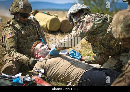 Us-Armee Pvt. Christian Avila, eine Combat medic für die Zentrale und die Konzernzentrale, 2nd Battalion 5th Cavalry Regiment, 1st Armored Brigade Combat Team zugewiesen sind, 1.Kavallerie Division, prüft die Vitalparameter eines simulierten Unfall während einer Tabelle VIII medizinische Ausübung, Novo Selo, Bulgarien, 27. August 2018. Tabelle VIII ist eine jährliche Veranstaltung der Bekämpfung des Medic lebensrettenden Fähigkeiten mit Hilfe von simulierten Schlachtfeld medizinische Notfälle zu testen. Stockfoto