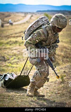 Us-Armee Pfc. Ardarius Schwarz, ein combat Medic für die Zentrale und die Konzernzentrale, 2nd Battalion 5th Cavalry Regiment, 1st Armored Brigade Combat Team zugewiesen sind, 1.Kavallerie Division, transportiert einen simulierten Unfall auf einem skedco während einer Tabelle VIII medizinische Ausübung, Novo Selo, Bulgarien, 27. August 2018. Tabelle VIII ist eine jährliche Veranstaltung der Bekämpfung des Medic lebensrettenden Fähigkeiten mit Hilfe von simulierten Schlachtfeld medizinische Notfälle zu testen. Stockfoto