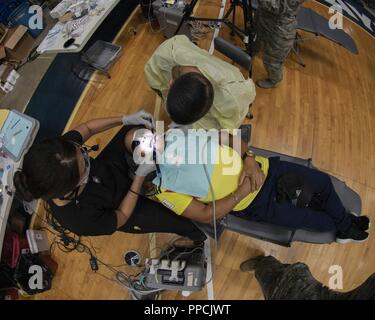 Us Navy Reserve Petty Officer 2nd class Tina Girot, Zahnarzthelfer mit Expeditionary medizinischen Einrichtung, große Seen, Loslösung L und US Navy Reserve Krankenhaus Corspman Klasse Xavier Chacon, EMF Dallas, führen Sie zahnmedizinische Dienstleistungen im Coliseo Mario Quijote Morales für Innovative Readiness Training Ola de Esperanza Sanadora Aug.31, 2018, in Guaynabo, Puerto Rico. Der Zweck des IRT ist medizinische, zahnmedizinische und Optometrie Pflege lokalen städtischen Behörden bei der Bewältigung underserved Gemeinschaft Gesundheit und gesellschaftliche Bedürfnisse, die sich während der gemeinsamen militärischen humanitären Aktionen zu unterstützen Stockfoto