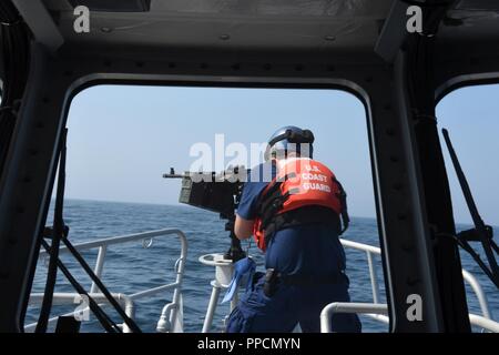 Eine Station der Woods Hole Crew steht hinter einer M 240 Maschine Bravo Pistole für die Bestellung Feuer Nomans Land, Massachusetts, Mittwoch, 12.08.29, 2018 wartend bereit. Coast Guard Station Woods Hole ist in Woods Hole, Massachusetts. Stockfoto