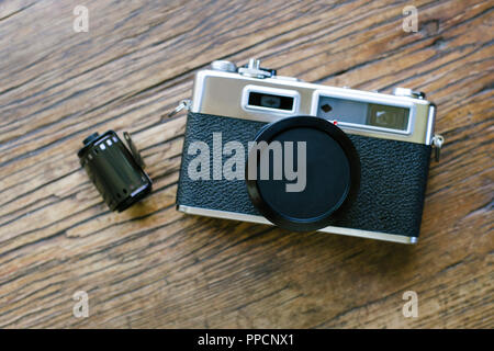 Alten retro Film Kamera auf einem Tisch mit einer Folienrolle Stockfoto