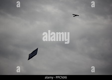 Kleiner Motor Flugzeug fliegen durch die Luft und ziehen eine Anzeige. Stockfoto