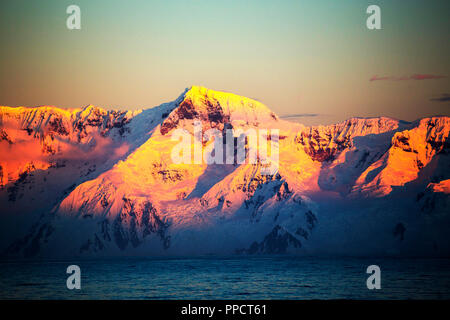 Abendlicht über Berge von der Gerlache Strait trennt das Palmer Archipel von der Antarktischen Halbinsel aus Anvers Island. Die antartic Peninsula ist eine der schnellsten Erwärmung Gebiete des Planeten. Stockfoto