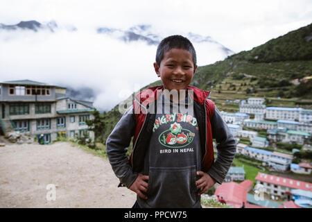 Eine junge Nepalesische boy steht für ein Foto in Namche Bazaar, die solu Khumbu Bezirke letzte Stadt während der trekking Trail in Richtung Mt Everest, Nepal Stockfoto