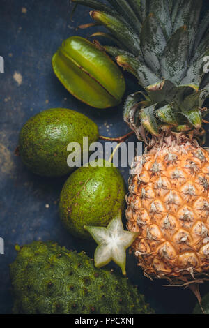 Reife tropische Früchte auf einer konkreten türkis Hintergrund Stockfoto
