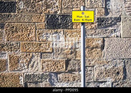 Keine Parkplätze Montag bis Freitag tagsüber Schild auf Stein Wand einfach Hintergrund Stockfoto