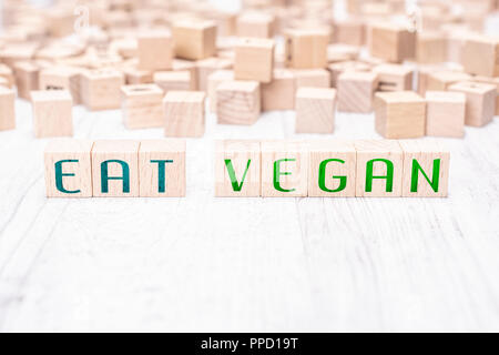 Die Worte essen Vegan gebildet von hölzernen Blöcke auf einem weißen Tisch Stockfoto