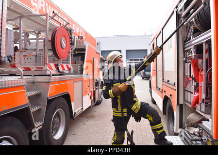 Porträt eines Feuerwehrmann am Einsatzfahrzeug in der Feuerwache Stockfoto
