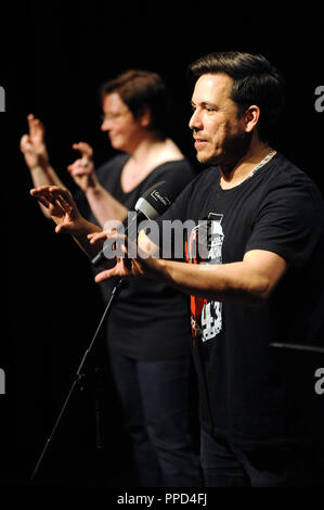 Die amerikanische Doppel slam Weltmeister Joaquin Zihuatanejo (er ist Zuhören), mit einem Interpreter auf der Bühne am Gasteig in München. Stockfoto