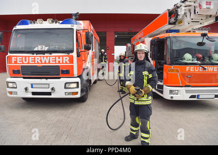 Gruppe von Feuerwehrleuten Am Einsatzfahrzeug in der Feuerwache Stockfoto