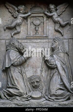 Der heilige Hieronymus (Stridon, 347 - 420). Einsiedler und Doktor der Kirche. Der hl. Paula von Rom (347-404). Römische saint und frühen Wüste Mutter. Relief mit zwei heiligen Verehrung des Allerheiligsten Sakraments. Skulpturen von der Werkstatt der Leoni, barocken Stil. Fassade der Kirche des Klosters von Corpus Christi (Las Carboneras), 1615-1625. Madrid, Spanien. Stockfoto