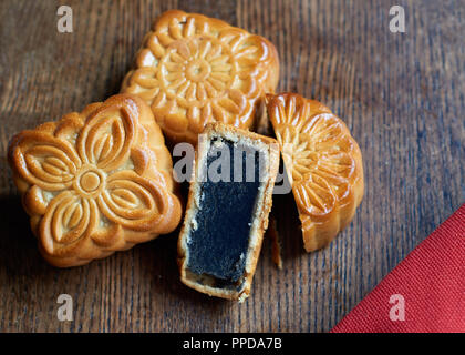 Mooncake halbiert auf dem hölzernen Hintergrund Stockfoto