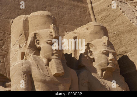 Ägyptische Kunst Großen Tempel von Ramses II. Zwei kolossale Statuen, die den Pharao Ramses II (1290-1224 v. Chr.) Mit dem nemes Kopf sitzt und durch die doppelte Krone überragt. 19. Dynastie. Neuen Reich. Abu Simbel. Ägypten. Stockfoto